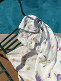 Any 2 Muslin Blankets Bundle - two Ari Baby muslin swaddle prints draped over a poolside chair